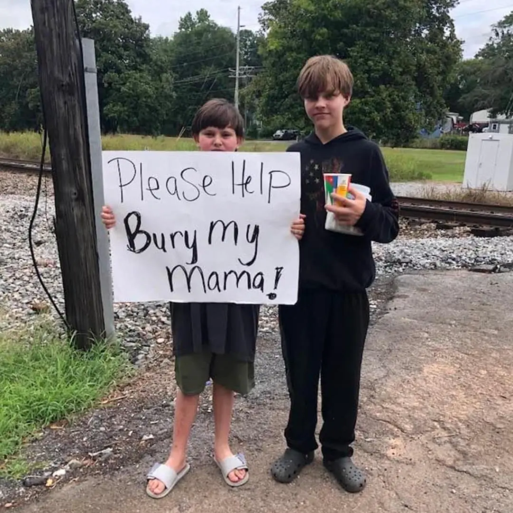 Lindale, Georgia: Boy holds sign to raise funds for mother’s funeral