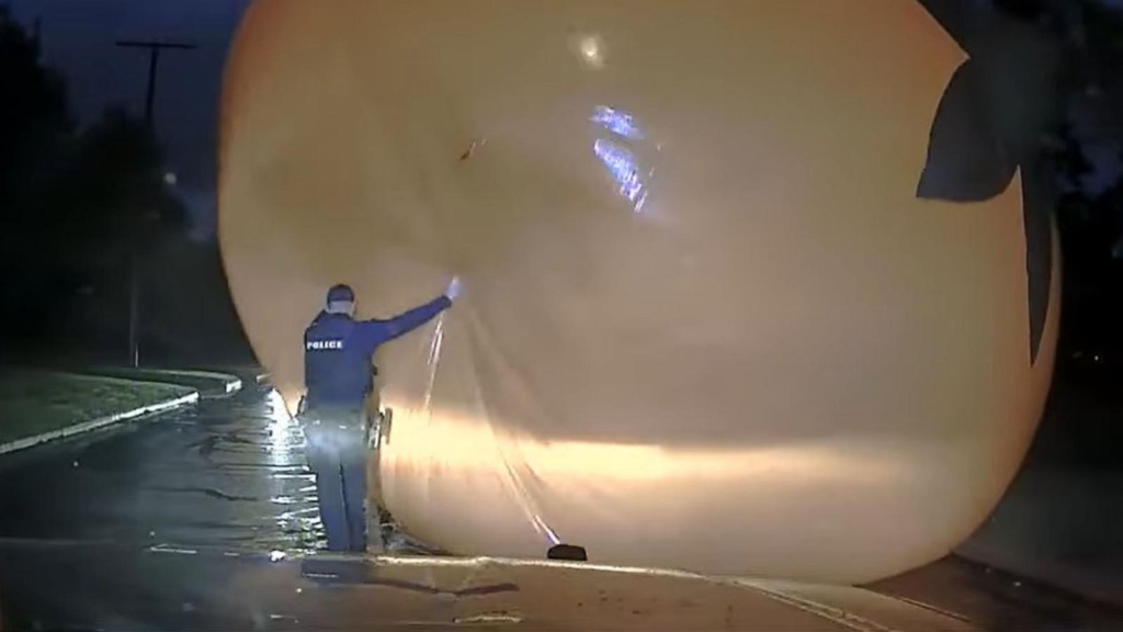 In an unusual encounter just outside Cleveland, a Bay Village police officer found himself in an unexpected “battle” with a giant inflatable pumpkin that had blown into the middle of the road. The incident, caught on dashcam footage, shows the officer attempting to clear the roadway when gusty winds turned the massive pumpkin into a formidable, rolling obstacle.